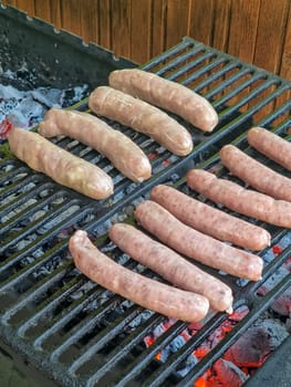 Delicious german sausages sizzling over the coals on barbecue grill