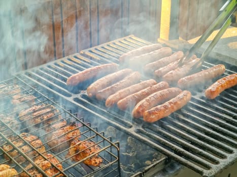 Delicious german sausages sizzling over the coals on barbecue grill