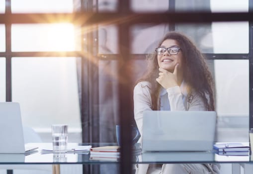 Young businesswoman using laptop at table in office