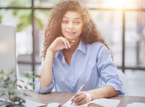 Business woman holding pens and papers making notes in documents on the table