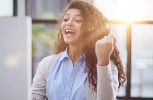expressive young woman open mouth checking discounts for online shopping sitting at desktop .
