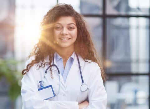 Portrait of young woman doctor with white coat standing in hospital