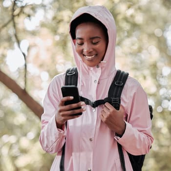 Black woman, phone and smile for hiking communication, social media or chatting in nature. Happy African female person or hiker smiling on mobile smartphone for trekking, travel or online location.