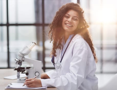 Attractive female scientist looking through a microscope