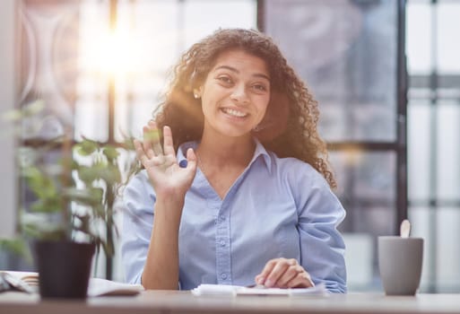 Smiling businesswoman or helpline operator with headset and computer at office