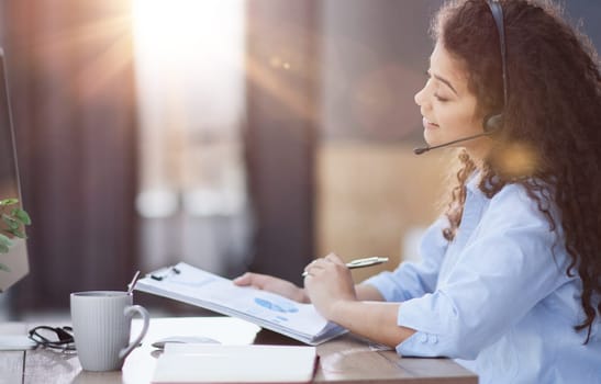 Side view of cheerful operator in headset in office