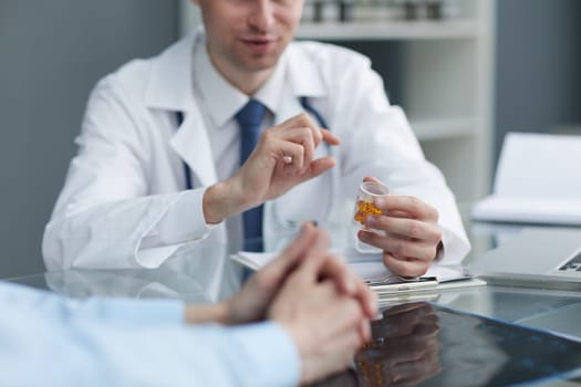 Pharmacist showing up a yellow pills in bottle