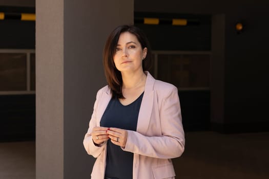 Portrait Confident Mature 40 yo Beautiful Woman, Professional Psychologist. Intelligent Caucasian Burnette Female With Brown Eyes Looks At Camera, Wears Pink Jackets, Blue Shirt. Horizontal Plane.