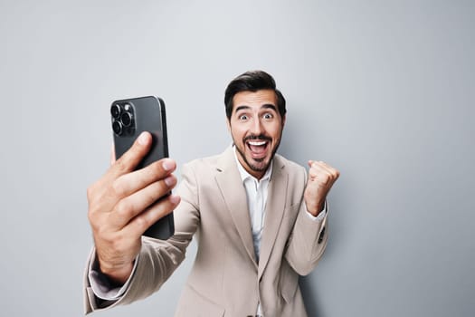 portrait man smile hold smartphone male white beige suit business happy success gray phone person entrepreneur call lifestyle connection adult technology