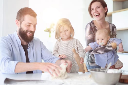 Young family with daughter and son in the kitchen
