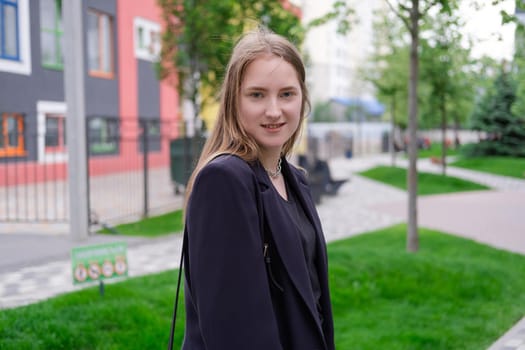 pretty brunette woman on background of bright modern buildings. feminine. millennial people. lady on walk.