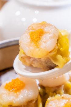 Siu Mai, one of Dim Sum yum cha, pork and shrimp steamed dumplings on restaurant house white background table for breakfast, lifestyle, close up.