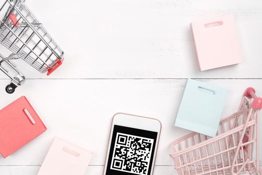 Abstract online shopping, mobile payment with QR code design concept element, colorful cart, paper bag on wooden table background, top view, flat lay