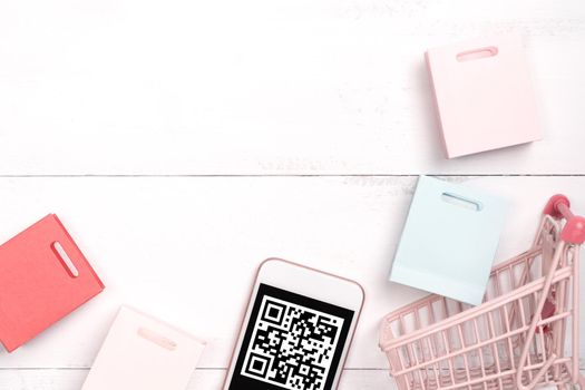 Abstract online shopping,mobile payment with QR code design concept element,colorful cart,paper bag on wooden table background,top view,flat lay