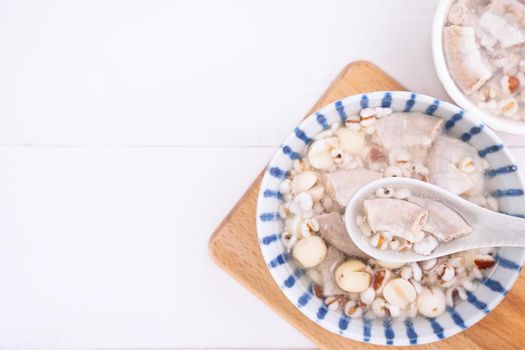 Tasty Four Tonics Herb Flavor Soup, Taiwanese traditional food with herbs, pork intestines on white wooden table, close up, flat lay, top view.