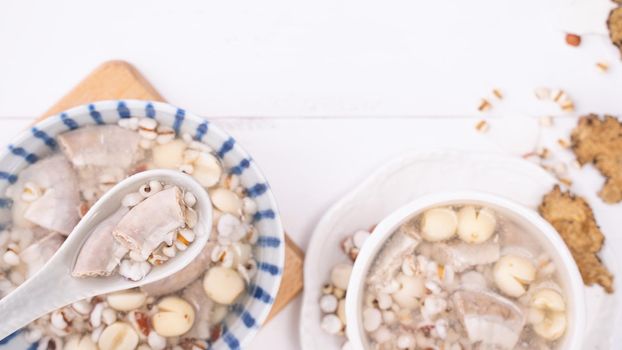 Tasty Four Tonics Herb Flavor Soup, Taiwanese traditional food with herbs, pork intestines on white wooden table, close up, flat lay, top view.