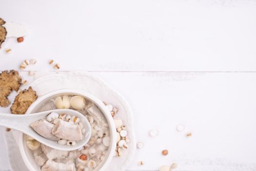Tasty Four Tonics Herb Flavor Soup, Taiwanese traditional food with herbs, pork intestines on white wooden table, close up, flat lay, top view.