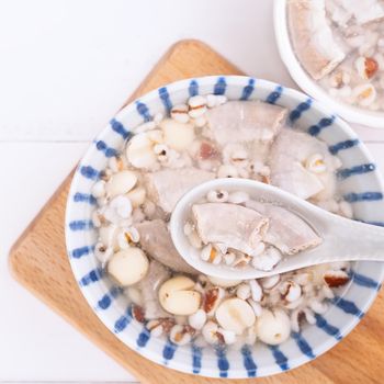 Tasty Four Tonics Herb Flavor Soup, Taiwanese traditional food with herbs, pork intestines on white wooden table, close up, flat lay, top view.