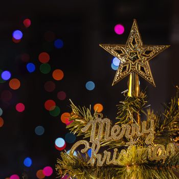 Beautiful Christmas decor concept, bauble hanging on the Christmas tree with sparkling light spot, blurry dark black background, macro detail, close up.