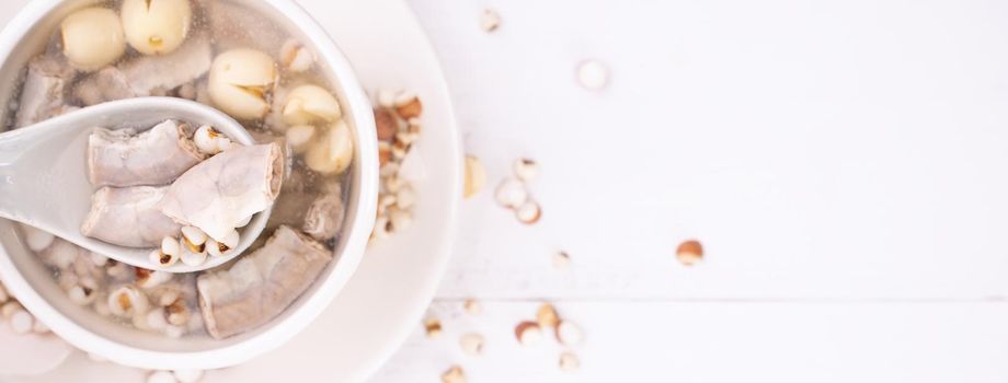 Tasty Four Tonics Herb Flavor Soup, Taiwanese traditional food with herbs, pork intestines on white wooden table, close up, flat lay, top view.