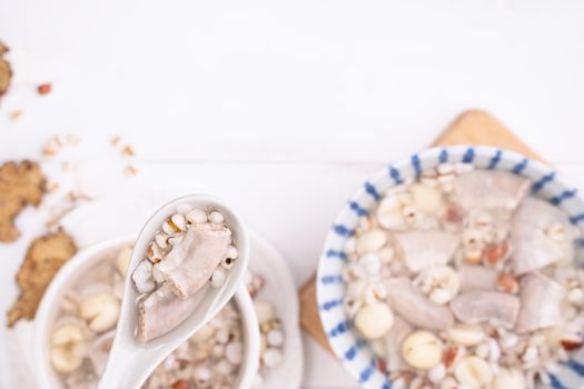 Tasty Four Tonics Herb Flavor Soup, Taiwanese traditional food with herbs, pork intestines on white wooden table, close up, flat lay, top view.