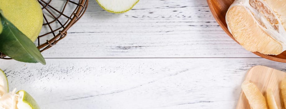 Fresh peeled pomelo, pummelo, grapefruit, shaddock on bright wooden background. Autumn seasonal fruit, top view, flat lay, tabletop shot.