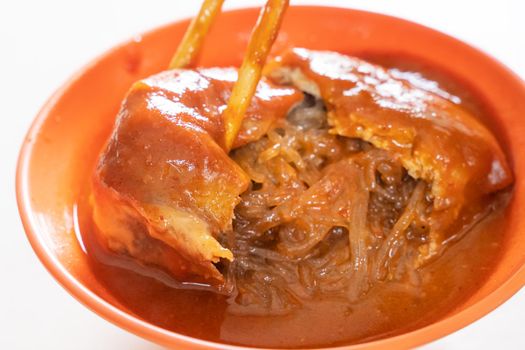 Tamsui agei (age, aburaage), delicious famous street food in Taipei, Taiwan, stuffed with mung bean noodles and chili sauce topping, lifestyle, close up.