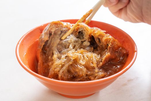 Tamsui agei (age, aburaage), delicious famous street food in Taipei, Taiwan, stuffed with mung bean noodles and chili sauce topping, lifestyle, close up.