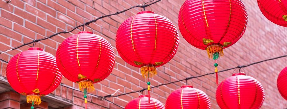 Beautiful round red lantern hanging on old traditional street, concept of Chinese lunar new year festival, close up. The undering word means blessing.