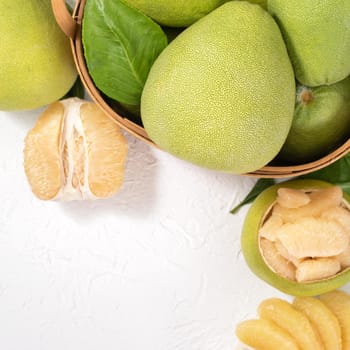 Fresh peeled pomelo, pummelo, grapefruit, shaddock on bright wooden background. Autumn seasonal fruit, top view, flat lay, tabletop shot.