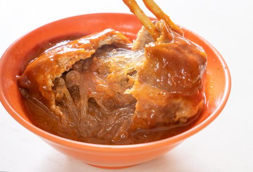 Tamsui agei (age, aburaage), delicious famous street food in Taipei, Taiwan, stuffed with mung bean noodles and chili sauce topping, lifestyle, close up.