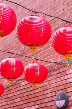 Beautiful round red lantern hanging on old traditional street, concept of Chinese lunar new year festival, close up. The undering word means blessing.