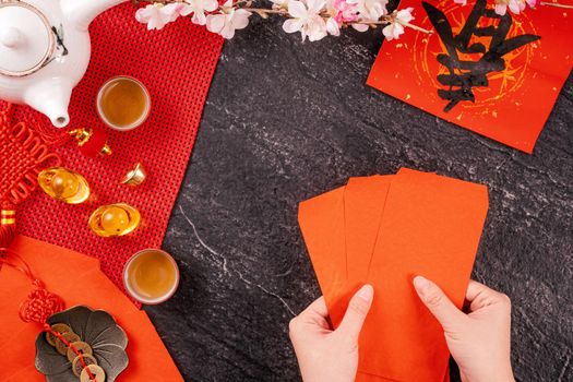 Design concept of Chinese lunar January new year - Woman holding, giving red envelopes (ang pow, hong bao) for lucky money, top view, flat lay, overhead above. The word 'chun' means coming spring.