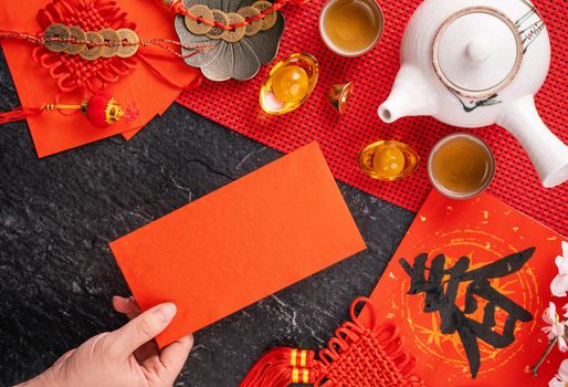 Design concept of Chinese lunar January new year - Woman holding, giving red envelopes (ang pow, hong bao) for lucky money, top view, flat lay, overhead above. The word 'chun' means coming spring.