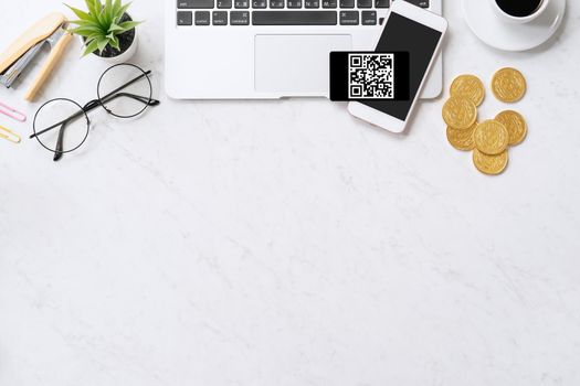 Online payment with QR code concept, virtual credit card, smart phone on office laptop desk on clean marble table background, top view, flat lay