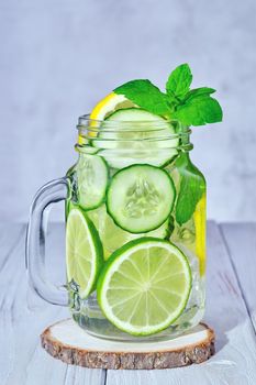Glass with fresh organic detox cucumber water with lime and lemon on white background.
