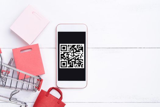 Abstract online shopping, mobile payment with QR code design concept element, colorful cart, paper bag on wooden table background, top view, flat lay