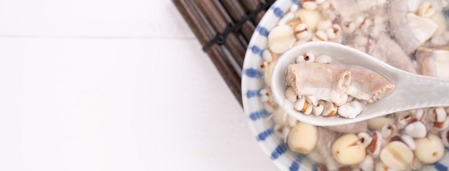 Tasty Four Tonics Herb Flavor Soup, Taiwanese traditional food with herbs, pork intestines on white wooden table, close up, flat lay, top view.