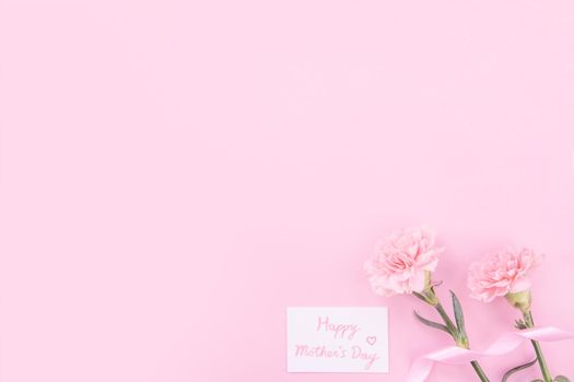Beautiful, fresh elegant carnation flower bouquet with white greeting thanks gift card isolated on bright pink color background, top view, flat lay concept.
