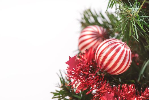 Decorated cute Christmas tree on a wooden floor with white background and toys, blank for festive design concept, close up.