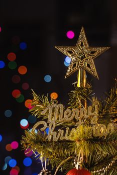 Beautiful Christmas decor concept, bauble hanging on the Christmas tree with sparkling light spot, blurry dark black background, macro detail, close up.