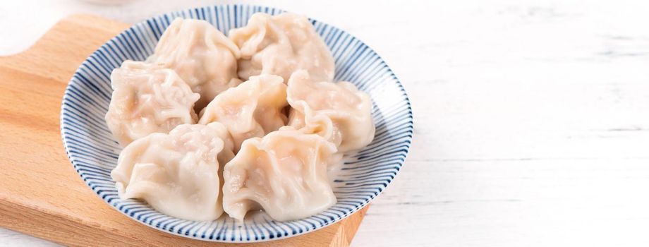 Fresh, delicious boiled pork, shrimp gyoza dumplings on white background with soy sauce and chopsticks, close up, lifestyle. Homemade design concept.