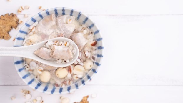 Tasty Four Tonics Herb Flavor Soup, Taiwanese traditional food with herbs, pork intestines on white wooden table, close up, flat lay, top view.