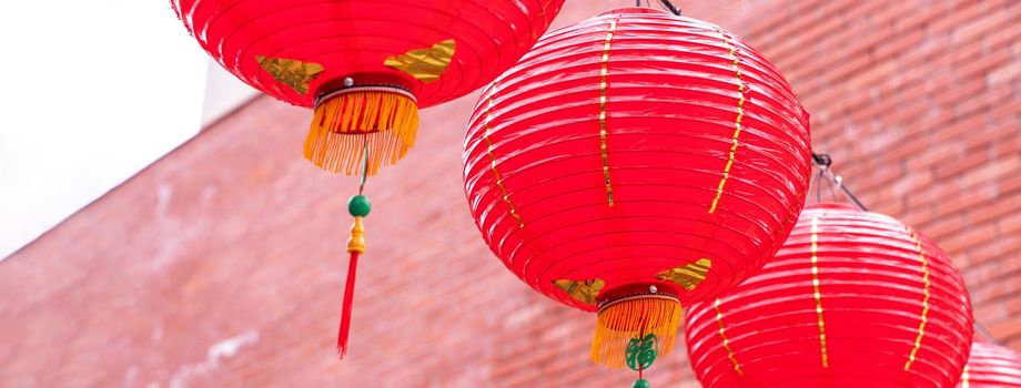 Beautiful round red lantern hanging on old traditional street, concept of Chinese lunar new year festival, close up. The undering word means blessing.