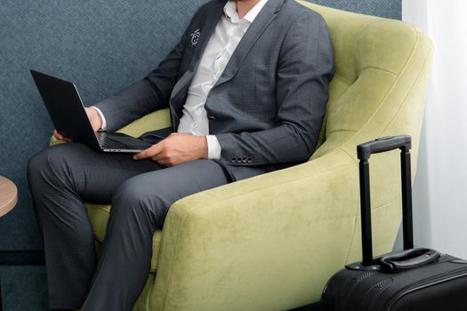Young businessman working on laptop, sitting in hotel
