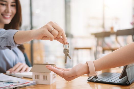 Client taking keys from female real estate agent during meeting after signing rental lease contract or sale purchase agreement. Independent woman purchasing new home, close up view