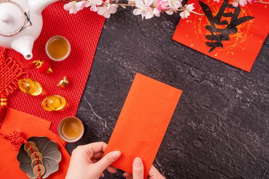 Design concept of Chinese lunar January new year - Woman holding, giving red envelopes (ang pow, hong bao) for lucky money, top view, flat lay, overhead above. The word 'chun' means coming spring.
