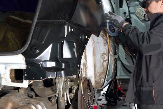 Cutting metal part with sparks in car service station