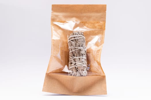 Isolated White Sage Smudge Stick In Paper Package On White Background. Horizontal Plane. Spiritual Incense For Energy Clearing And Healing. High quality photo
