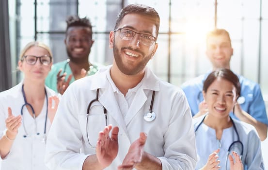 Successful team of young doctors clapping their hands